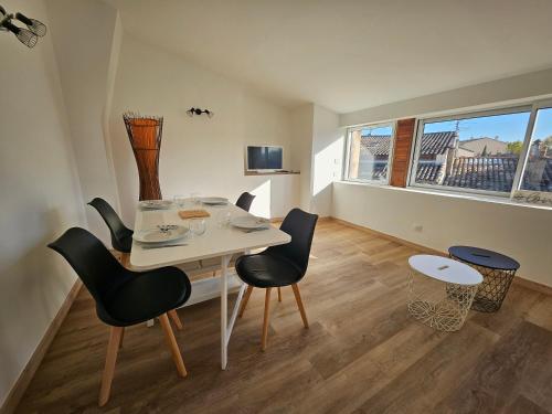 a dining room with a white table and chairs at Sur les toits in Draguignan