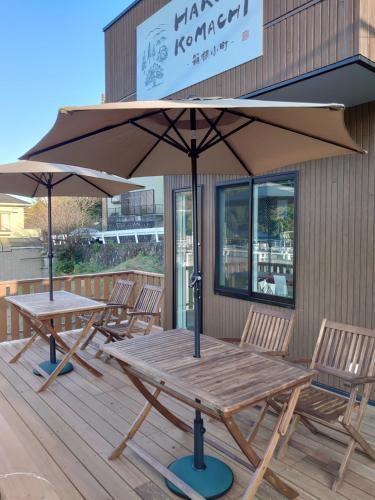 - une table de pique-nique en bois avec un parasol sur la terrasse dans l'établissement Hakone Komachi-箱根小町, à Hakone