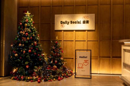 Un arbre de Noël dans un bâtiment avec un panneau dans l'établissement Sheraton Guangzhou Hotel, à Canton