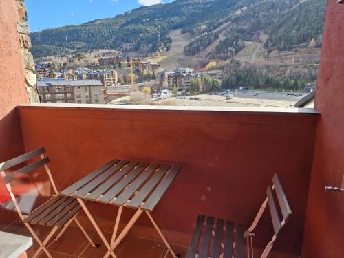 un banco y 2 sillas en un balcón con vistas en Elegante 5 estrellas en Grandvalira El Tarter, en Canillo