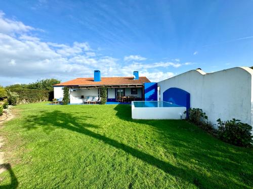 ein Haus mit einem großen Hof neben einem Gebäude in der Unterkunft Comporta - Wood & Blue in Comporta