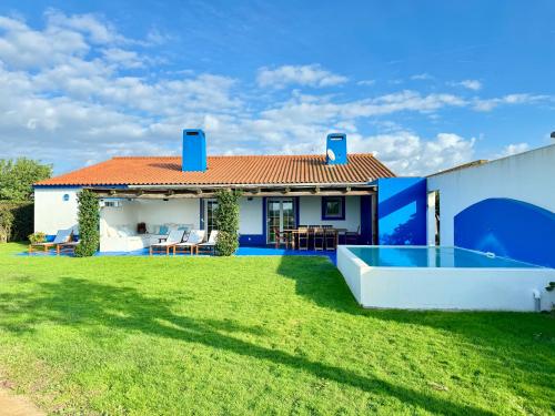 ein Haus mit einem Garten mit Pool in der Unterkunft Comporta - Wood & Blue in Comporta