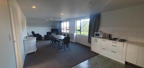 een keuken en een woonkamer met een tafel en stoelen bij The Haven Newmarket Suites in Auckland