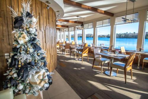 a christmas tree in a restaurant with tables and chairs at Estérel Resort in Esterel