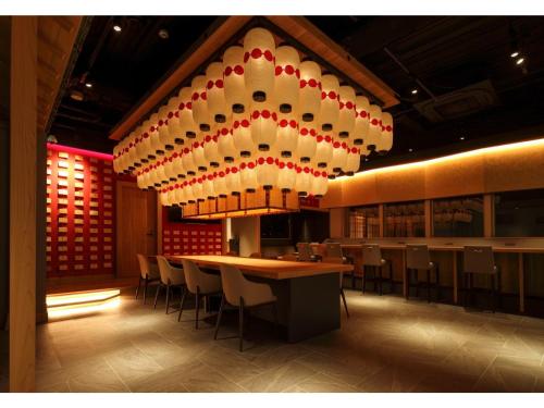 un ristorante con tavolo, sedie e lampadario a braccio di NINJA & GEISHA - Vacation STAY 80336v ad Osaka