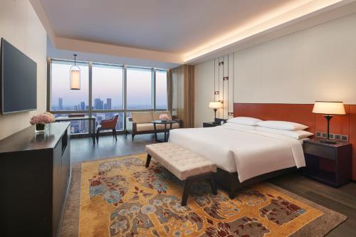 ein Schlafzimmer mit einem großen Bett und ein Wohnzimmer in der Unterkunft Grand Hyatt Changsha in Changsha