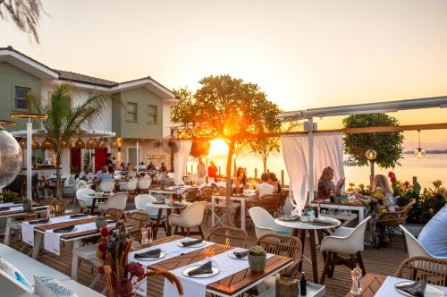 - un restaurant sur la plage avec des tables dans l'établissement Carpe Diem Boutique Hotel - Adults Only, à Sidé