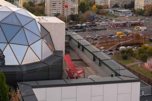 una silla roja se sienta en el techo de un edificio en Be The One Hotel, en Kiev