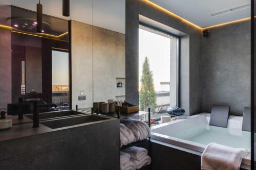 baño con bañera y ventana grande en Be The One Hotel, en Kiev