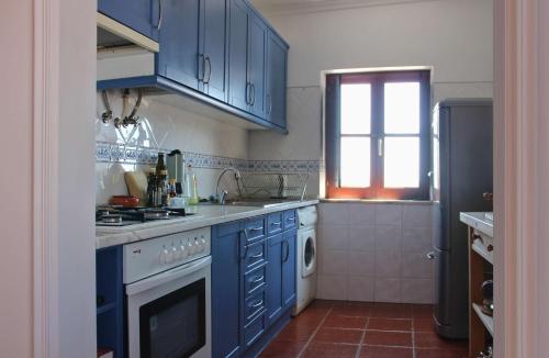 a kitchen with blue cabinets and a stove top oven at Penthouse Alentejana in Vila Nova de Milfontes