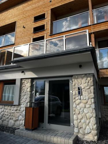 un edificio con una porta di vetro di fronte di Apartmán Tatranská Štrba Vysoké Tatry a Poprad