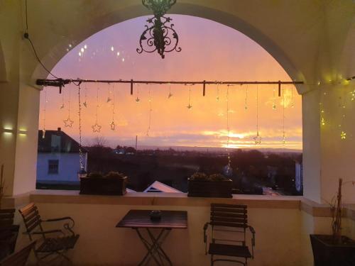 an arched window with a view of the sunset at Freigut Thallern in Gumpoldskirchen