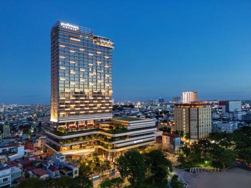 um edifício alto numa cidade à noite em Pullman Hai Phong Grand Hotel em Hai Phong