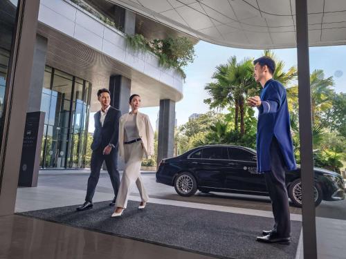 uma representação de três pessoas andando em frente a um edifício com um carro em Pullman Hai Phong Grand Hotel em Hai Phong