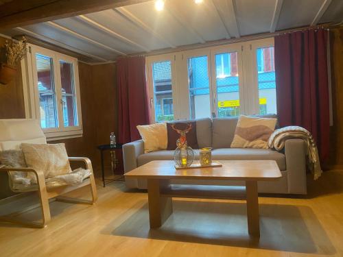 a living room with a couch and a coffee table at Cosy apartment in heritage protected swiss chalet in Matten