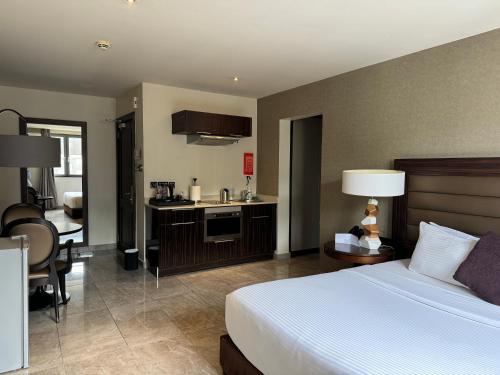 a hotel room with a bed and a kitchen at The Palms by Eagles Accra in Accra