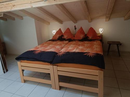 Bett mit roten Kissen in einem Zimmer in der Unterkunft Apartment Lischa by Interhome in Fiesch