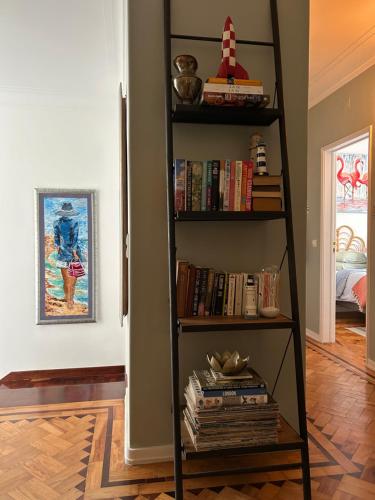 a black book shelf filled with books in a room at MAR VERDE - Parede-Cascais in Parede