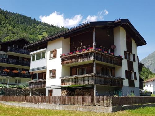 ein Gebäude mit einem Balkon mit Blumen darauf in der Unterkunft Apartment Lischa by Interhome in Fiesch