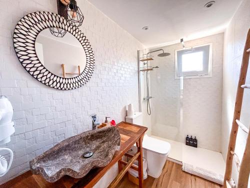 La salle de bains est pourvue d'un lavabo et d'un miroir. dans l'établissement Chakra House Fuerteventura - Affordable Rooms in a Cozy Guesthouse, à Corralejo