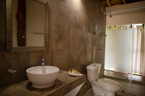 a bathroom with a sink and a toilet at Kabañas Ojo de Agua in Puerto Morelos