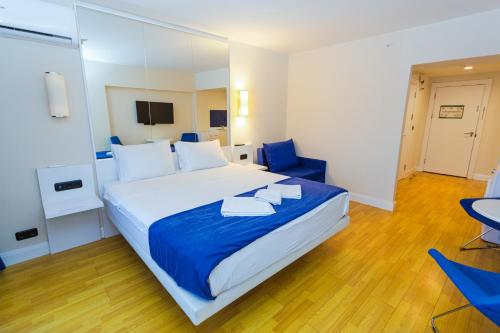 a hotel room with a large bed with blue chairs at VIP APARTmENTS N10 in Batumi