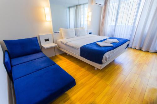 a bedroom with a blue bed and a couch at VIP APARTmENTS N10 in Batumi