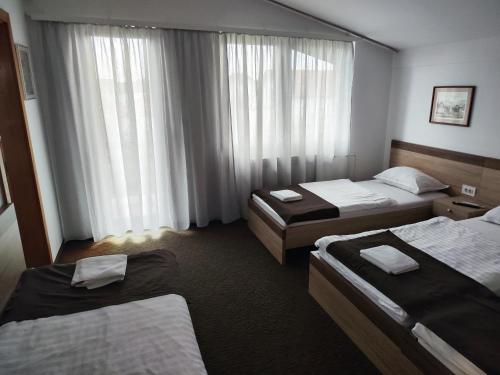 um quarto de hotel com duas camas e uma janela em TIM rooms em Velika Gorica