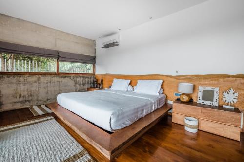 - une chambre avec un grand lit et une fenêtre dans l'établissement Beachfront Villa Nakar Two, à Jimbaran