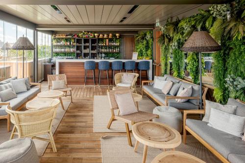 a room with chairs and a bar with plants at Grand Hotel Bellevue - Grand Place in Lille