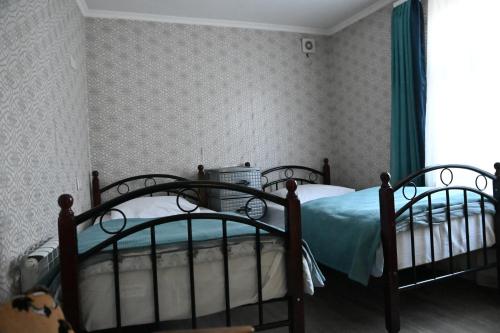 a bedroom with two beds and a window at Babulya House in Gyumri