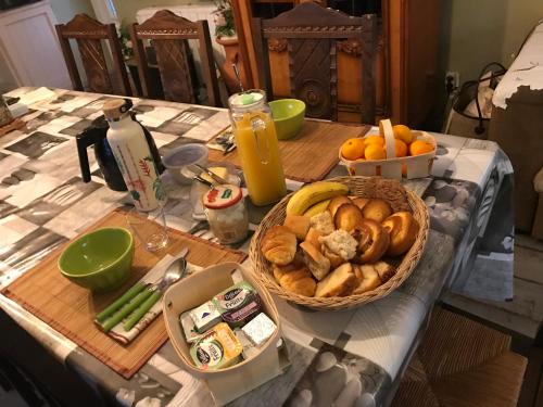 een tafel met twee manden brood en sinaasappels bij l'Ancienne Forge in Aigonnay