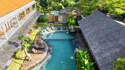 una vista aérea de una piscina con sillas y una casa en Puri Andong Villa, en Ubud