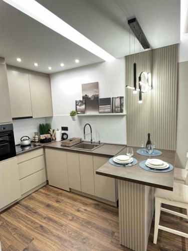 a kitchen with a sink and a counter with plates on it at Premium Line Apartman in Sombor