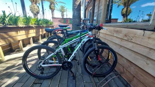 2 biciclette sono parcheggiate accanto a un muro di Las Palmas Beach Hostel a La Paloma