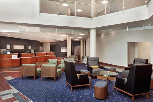 un hall avec des chaises et des tables ainsi qu'une salle d'attente dans l'établissement Courtyard by Marriott Ottawa East, à Ottawa