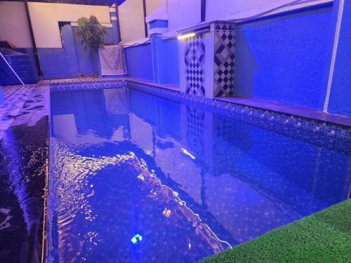 uma piscina à noite com luzes azuis em Gateaway Villa ll 3BHK ll Swimming Pool ll TableTennis ll AC em Lonavala