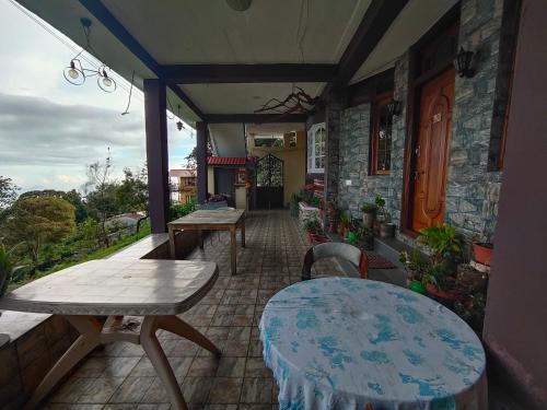 een patio met tafels en stoelen in een gebouw bij MISBHA HomeStay in Kodaikānāl