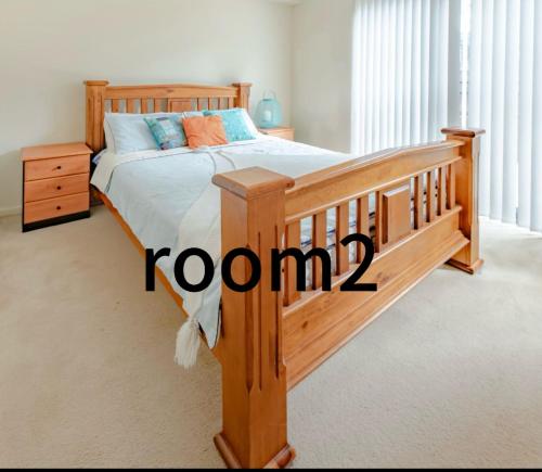 - une chambre avec un lit en bois et un cadre en bois dans l'établissement 3号房源爱旅家园整套, à Baulkham Hills