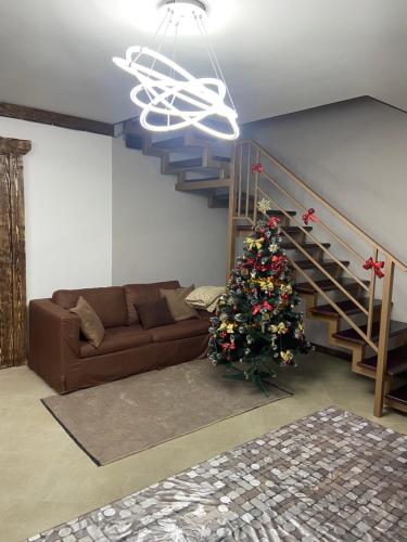 una sala de estar con un árbol de Navidad y una escalera en VIP котедж Рокита, en Mykulychyn