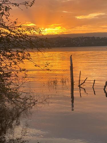 un palo in acqua con un tramonto sullo sfondo di Parque Hotel a Villa Carlos Paz