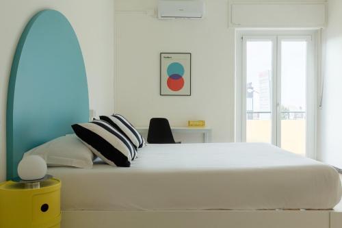 um quarto com uma grande cama branca com almofadas em Spacebility Airport - self check-in em Cagliari