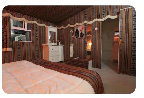 a bedroom with a large bed with a dresser at بيرحاء إبراء للسياحة in Ibrā