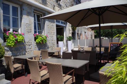 un patio extérieur avec des tables, des chaises et des parasols dans l'établissement Hotel Val Saint Hilaire, à Givet