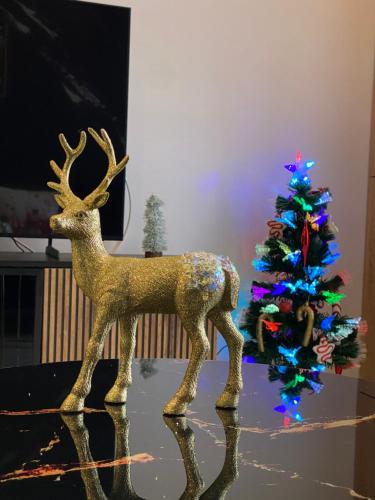 une statue d'un cerf à côté d'un arbre de Noël dans l'établissement Gold Star Black Cosmopolis, à Creţuleasca