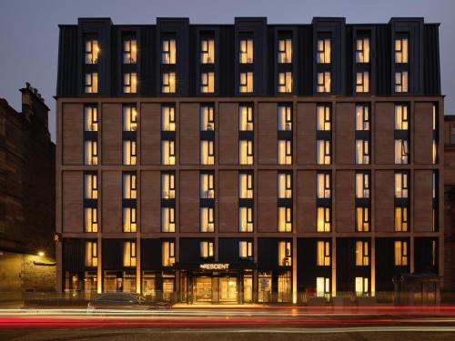 un edificio con finestre illuminate su una strada cittadina di The Resident Edinburgh - Newly Open a Edimburgo