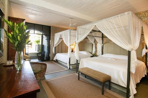 a bedroom with a canopy bed and a table at Quinta Maria Cortez in Puerto Vallarta