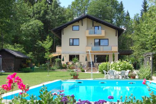 une maison avec une piscine en face de celle-ci dans l'établissement Haus am Wald, à Faak am See