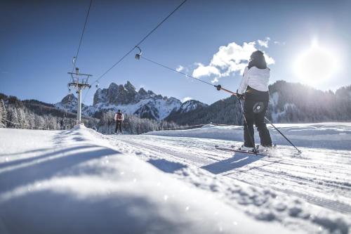 una persona en esquís en un remonte en la nieve en Hotel Gratschwirt, en Dobbiaco