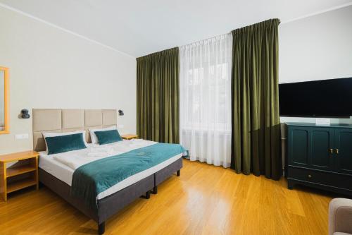 um quarto com uma cama e uma televisão de ecrã plano em Perła Sudetów by Stay inn Hotels em Karpacz